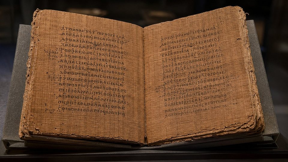 Un petit codex de papyrus ouvert, couvert d'une écriture grecque majuscule régulière