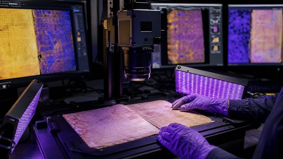 Laboratoire sombre : un feuillet ancien photographié sous des panneaux de lumière bleue et ultraviolette