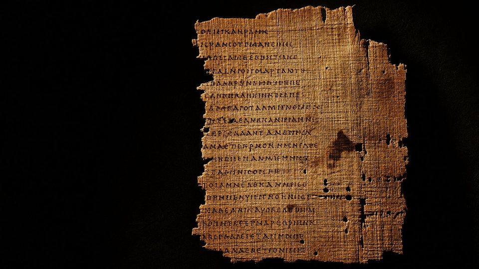 Un fragment de papyrus grec déchiré, couvert d'une quarantaine de lignes d'écriture, sur fond noir